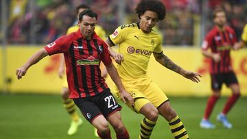 Freiburg's Nicolas Hoefler, left, and Dortmund's Axel Witsel, right, challenge for the ball during the German Bundesliga soccer match between SC Freiburg and Borussia Dortmund in Freiburg, Germany, Saturday, Oct. 5, 2019. (Patrick Seeger/dpa via