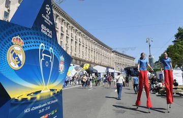 Women on stilts walk at the fan zone in Kiev on May 24, 2018, ahead of the 2018 UEFA Champions League Cup final football match between Real Madrid and Liverpool FC next May 26 at the Olimpiyskiy Stadium.