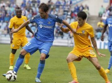 El centrocampista del Getafe, Michel Herrero, intenta controlar el balón ante el mediocampo del Málaga, Luis Alberto Romero, durante el partido de Liga de Primera División que los dos equipos disputan en el Coliseum Alfonso Pérez, en Getafe.