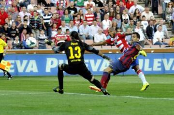 El delantero argelino del Granada Brahimi (c) marca ante Pinto (i) y Montoya, ambos del FC Barcelona, durante el partido de Liga en Primera División que disputan en el estadio Nuevo Los Cármenes, en Granada. 