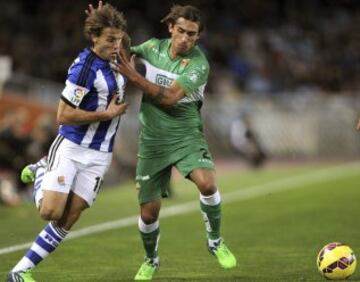 El jugador de la Real Sociedad Sergio Canales trata de escapar de Damián. 