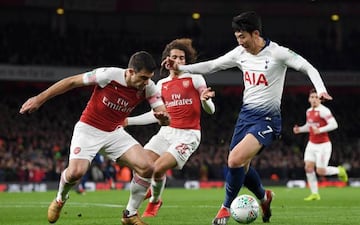 Heung-Min Son of Tottenham Hotspur is challenged by Sokratis Papastathopoulos of Arsenal during the Carabao Cup Quarter Final match between Arsenal and Tottenham Hotspur at Emirates Stadium on December 19, 2018 in London, United Kingdom.