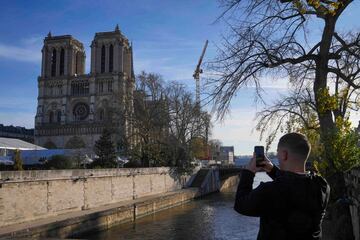 Un hombre fotografía con su móvil la catedral de Notre Dame de París. 