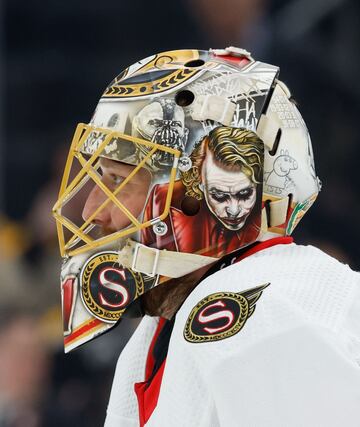 Este primer plano de Anton Forsberg, portero de los Ottawa Senators, muestra con detalle la curiosa decoración de su casco durante el partido de la NHL contra los Boston Bruins en el TD Garden de Boston, Massachusetts. En su cabeza tienen cabida desde villanos de la talla de Bane o The Joker hasta personajes tan entrañables como Peppa Pig.