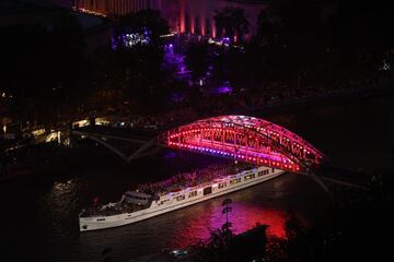 La barcaza del equipo de Francia pasa bajo la pasarela Debilly mientras navega por el río Sena durante el desfile de atletas.