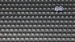 Staff members sit in spectator seats during an ice hockey test event for the 2022 Olympic Winter Games, inside the National Indoor Stadium in Beijing, China April 2, 2021. REUTERS/Tingshu Wang