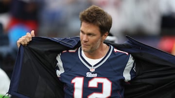 FOXBOROUGH, MASSACHUSETTS - SEPTEMBER 10 Former New England Patriots quarterback Tom Brady takes off his rain coat during a ceremony honoring Brady at halftime of New England's game against the Philadelphia Eagles at Gillette Stadium on September 10, 2023 in Foxborough, Massachusetts.   Adam Glanzman/Getty Images/AFP (Photo by Adam Glanzman / GETTY IMAGES NORTH AMERICA / Getty Images via AFP)