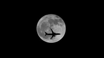 FILE PHOTO: A passenger plane passes the moon as it comes into land at the international airport in Chennai, India, September 25, 2018. REUTERS/P. Ravikumar/File Photo
