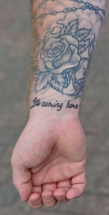 Seguidor inglés con la frase "It's coming home" tatuada en al muñeca.