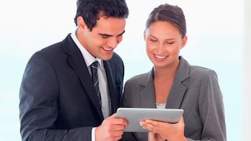 Un hombre y una mujer de negocios revisan información en una tablet.