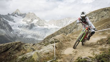 La piloto de MTB francesa Melanie Pugin en plena etapa de las EWS-E en Zermatt (Suiza) con los alpes de fondo nevados.