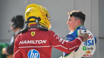 Ferrari's British driver Lewis Hamilton (L) greets Racing Bull's French driver Isack Hadjar (R) following the qualifying session of the Formula One Chinese Grand Prix at the Shanghai International Circuit in Shanghai on March 22, 2025. (Photo by Hector RETAMAL / AFP)