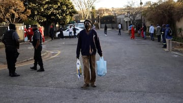 Johannesburg (South Africa), 06/08/2020.- A man walks away after receiving food during the weekly feeding scheme at the Heritage Baptist Church amid the coronavirus emergency lockdown in Melville, Johannesburg, South Africa, 06 August 2020. Volunteers fro