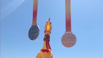 El pollo de plástico McPollo, la mascota de la selección española de marcha, posa con unas medallas durante un campeonato