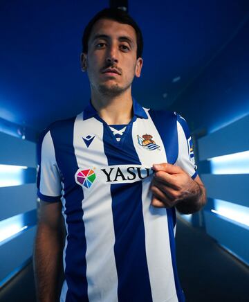 La equipaci¨®n home de la Real Sociedad rinde homenaje a las camisetas de la primera mitad del siglo XX con un dise?o retro. Se destaca su cuello estilo polo con corte vintage, adornado con cordones que evocan a los uniformes de esa ¨¦poca.