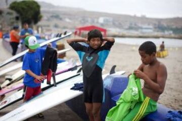 Varios niños asisten a clases de surf en una playa cerca de Alto Perú chabolas de Lima. Desde 2008, la ONG Alto Perú busca ofrecer a los niños de un barrio pobre de pescadores conocido como Alto Perú, la oportunidad de aprender y practicar deportes alternativos como el surf y el Muay Thai de forma gratuita.