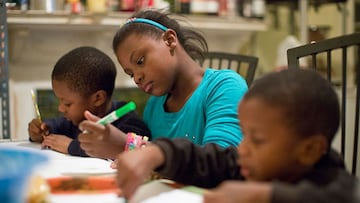 Una ni&ntilde;a ayuda a sus hermanos con un dibujo y una tarea en Filadelfia, USA, el 8 de octubre de 2013.