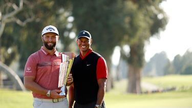 Jon Rahm posa junto a Tiger Woods con el trofeo de campeón del Genesis Invitational.