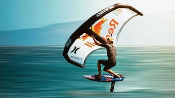 Kai Lenny practicando wing foil con una cometa personalizada y el fondo difuminado por la velocidad.