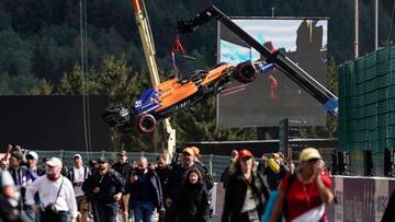 The car of McLaren&#039;s Spanish driver Carlos Sainz is lifted off the circuit as spectators make their way to the awarding ceremony after the Belgian Formula One Grand Prix at the Spa-Francorchamps circuit in Spa on September 1, 2019. (Photo by Kenzo TR