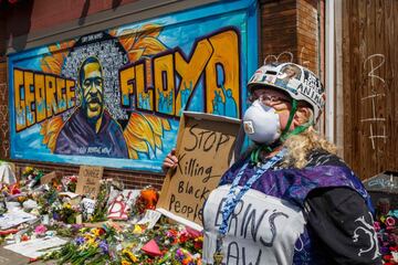 A protester stands near a memorial following a day of demonstration in a call for justice for George Floyd, who died while in custody of the Minneapolis police, on May 30, 2020 in Minneapolis, Minnesota. - Demonstrations are being held across the US after George Floyd died in police custody on May 25. (Photo by Kerem Yucel / AFP)