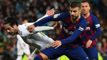 Isco y Piqué pugnan por un balón en el Clásico.