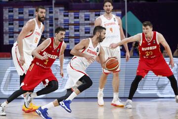 El capit芍n de la selecci車n espa?ola de baloncesto Juan Carlos Navarro intenta avanzar con el bal車n ante la oposici車n del base ruso Aleksei Shved.