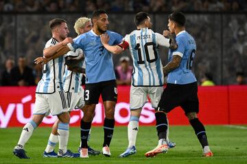 El mediocampista argentino Alexis Mac Allister, el mediocampista Rodrigo De Paul, el defensor uruguayo Sebastián Cáceres, el delantero argentino Lionel Messi y el defensor uruguayo Mathias Olivera discuten durante el partido de fútbol.