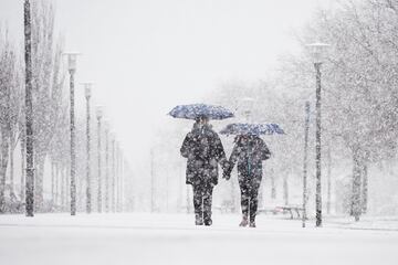 Una pareja camina bajo la nieve en Pamplona, Navarra. El fuerte temporal asociado a las borrascas Gérard y Fien ha hecho que Navarra amanezca hoy con abundantes precipitaciones de nieve en la zona norte y los primeros problemas para el tráfico. Una nevada que en algunos puntos de Navarra ha superado las previsiones, con acumulaciones de más de 20 centímetros, llegando a 40 en Belagua.