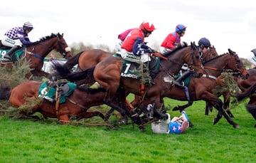 El hipódromo de Aintree, en Liverpool, se prepara para la cita más importante del año: el Grand National, que tendrá lugar mañana tras el Día de las Damas de hoy. Sin embargo, la fiesta de las carreras se empezó a vivir desde ayer. En la imagen, el jockey Ben Sutton se protege tras caer de Drop Flight para evitar ser pisado por los caballos.