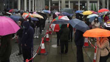 People line up for a nucleic acid test at a makeshift testing site set up next to a mobile testing vehicle dispatched from mainland China, following the coronavirus disease (COVID-19) outbreak, in Tung Chung, Hong Kong, China February 21, 2022. REUTERS/Lam Yik