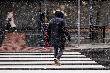 Un hombre camina bajo la nieve en Madrid.