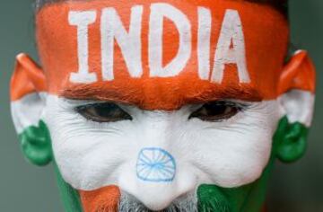 Un aficionado del equipo indio de cricket pinta su cara con la bandera del país.