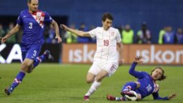 El centrocampista croata, Luka Modric (d) lucha por el bal&oacute;n con el serbio Filip Duricic (c) durante el partido clasificatorio del Mundial de Brasil 2014 que ambas selecciones disputaron en el estadio Stadion Maksimir.