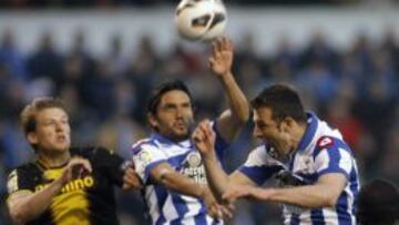 Carlos Marchena (d) cabecea el balón ante su compañero Abel Enrique (c) y el defensa Loovens durante el partido correspondiente a la trigésima jornada