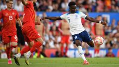 England's midfielder Bukayo Saka (R) shoots past North Macedonia's defender Gjoko Zajkov to score their fourth goal during the UEFA Euro 2024 group C qualification football match between England and North Macedonia at Old Trafford in Manchester, north west England, on June 19, 2023. (Photo by Oli SCARFF / AFP) / NOT FOR MARKETING OR ADVERTISING USE / RESTRICTED TO EDITORIAL USE