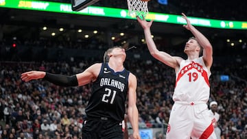 Feb 14, 2023; Toronto, Ontario, CAN; Toronto Raptors center Jakob Poeltl (19) goes after a rebound against Orlando Magic center Moritz Wagner (21) during the first half at Scotiabank Arena. Mandatory Credit: John E. Sokolowski-USA TODAY Sports