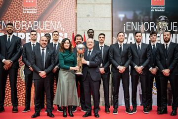 La presidenta de la Comunidad de Madrid, Isabel Díaz Ayuso (c), junto al presidente, Florentino Pérez (d), tras recibir al equipo, directiva y cuerpo técnico del Real Madrid, en la Real Casa de Correos. 