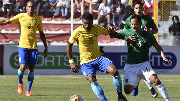 Brazil's Paulinho (C) controls the ball pressured by Bolivia's Leonel Justiniano (R) during their 2018 World Cup football qualifier match in La Paz on October 5, 2017. / AFP PHOTO / AIZAR RALDES