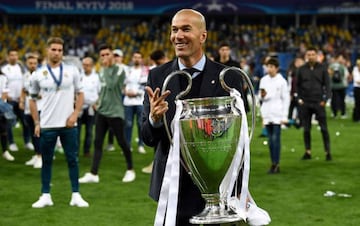 Another stadium down | Real Madrid's French coach Zinedine Zidane gestures the number three and holds the trophy as he celebrates winning the UEFA Champions League in the Olympic Stadium in Kiev.