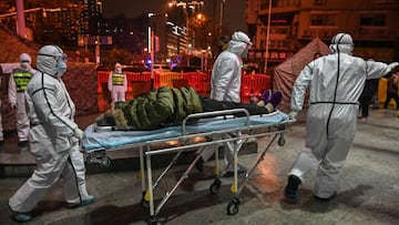 Especialistas médicos trasladan a un paciente de coronavirus al hospital en camilla.
