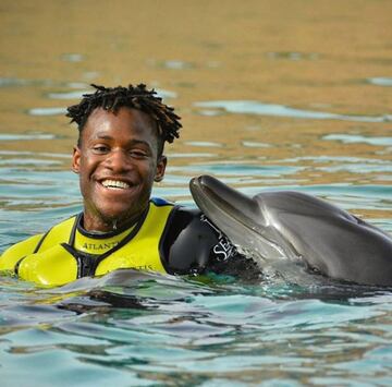 Además, le gustan los deportes acuáticos. En este imagen, divirtiendo con el delfín.