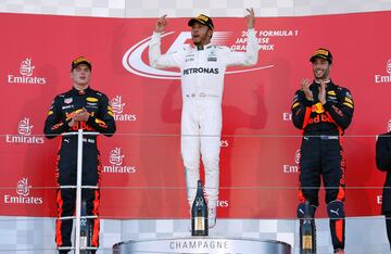 Lewis Hamilton celebra la victoria, flanqueado por Daniel Ricciardo y Max Verstappen.