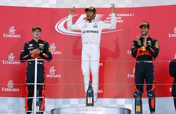 Lewis Hamilton celebra la victoria, flanqueado por Daniel Ricciardo y Max Verstappen.