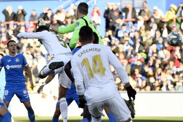 El jugador del Real Madrid, Varane, y el portero del Getafe, Soria, saltan hacia el balón en la jugada del 0-1.