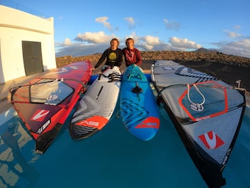 Daida Ruano (izquierda) posa junto a su hermana Iballa detrs de las tablas y velas de windsurf.