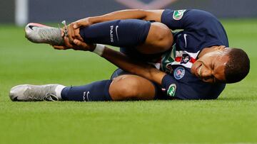 Soccer Football - Coupe de France - Final - Paris St Germain v AS Saint-Etienne - Stade de France, Saint-Denis near Paris, France - July 24, 2020 Paris St Germain's Kylian Mbappe reacts after sustaining an injury, following the outbreak of the coro