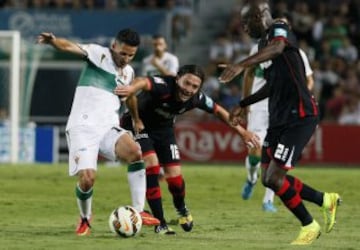 El centrocampista del Elche Ferrán Corominas lucha por el balón con el chileno Manuel Iturra.