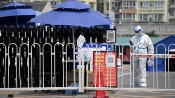 A security guard wearing personal protective equipment (PPE) stands at an entrance to a residential area under lockdown due to Covid-19 coronavirus restrictions in Beijing on June 20, 2022. (Photo by Noel Celis / AFP) (Photo by NOEL CELIS/AFP via Getty Images)