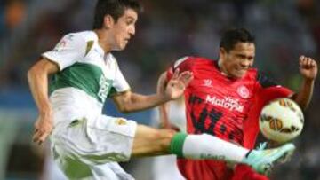 Elche's Chilenan defender Enzo Roco (L) vies with Sevilla's Colombian forward Carlos Bacca during the Spanish league football match Elche CF vs Sevilla FC at the Martinez Valero stadium in Elche on October 19, 2014. AFP PHOTO/ JOSE JORDAN